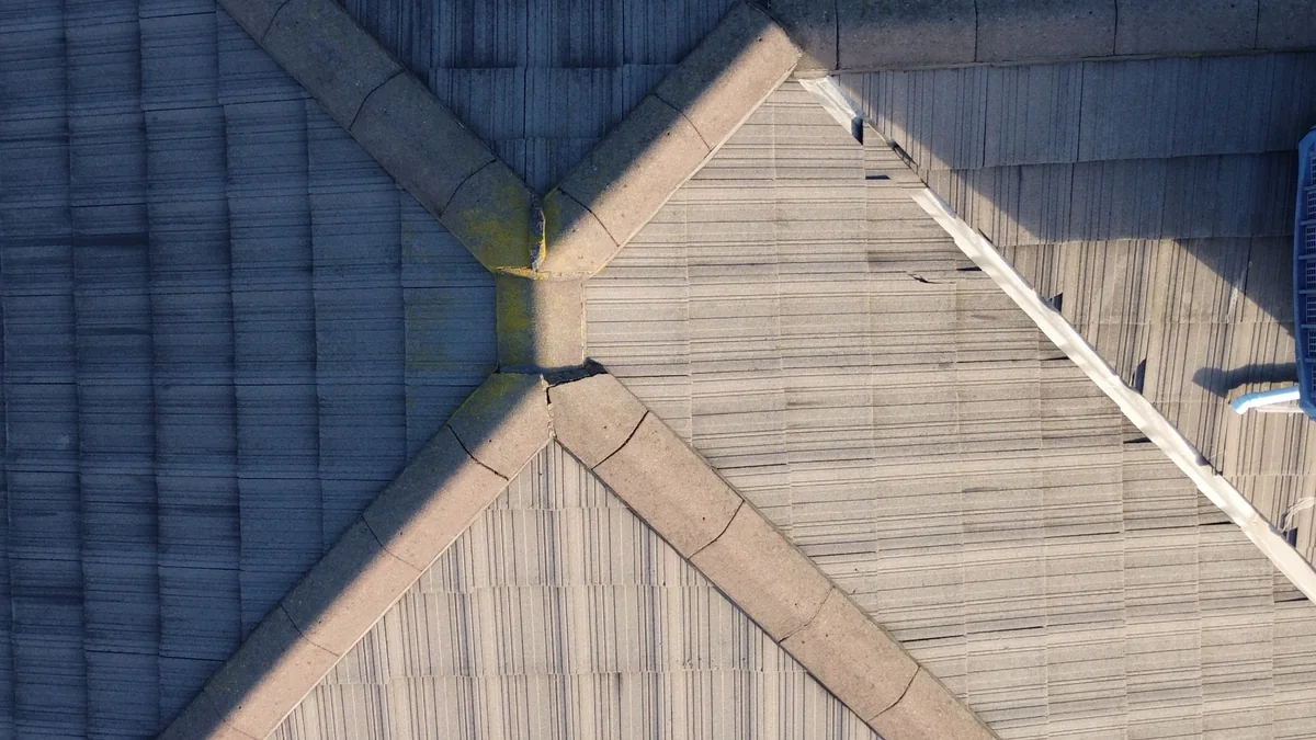 Closer overhead view of intersecting tiled roof planes and ridge lines